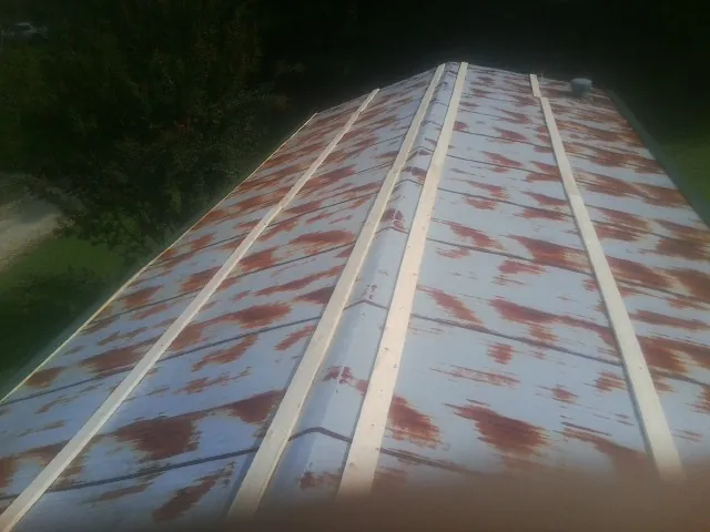 Rusted metal roof panels with new wood purlins before replacement — Storm Damage Roof Repair in Bellmore by Roofing Brothers