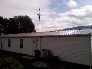 New metal roof on a single wide mobile home with a TV antenna in Bellmore