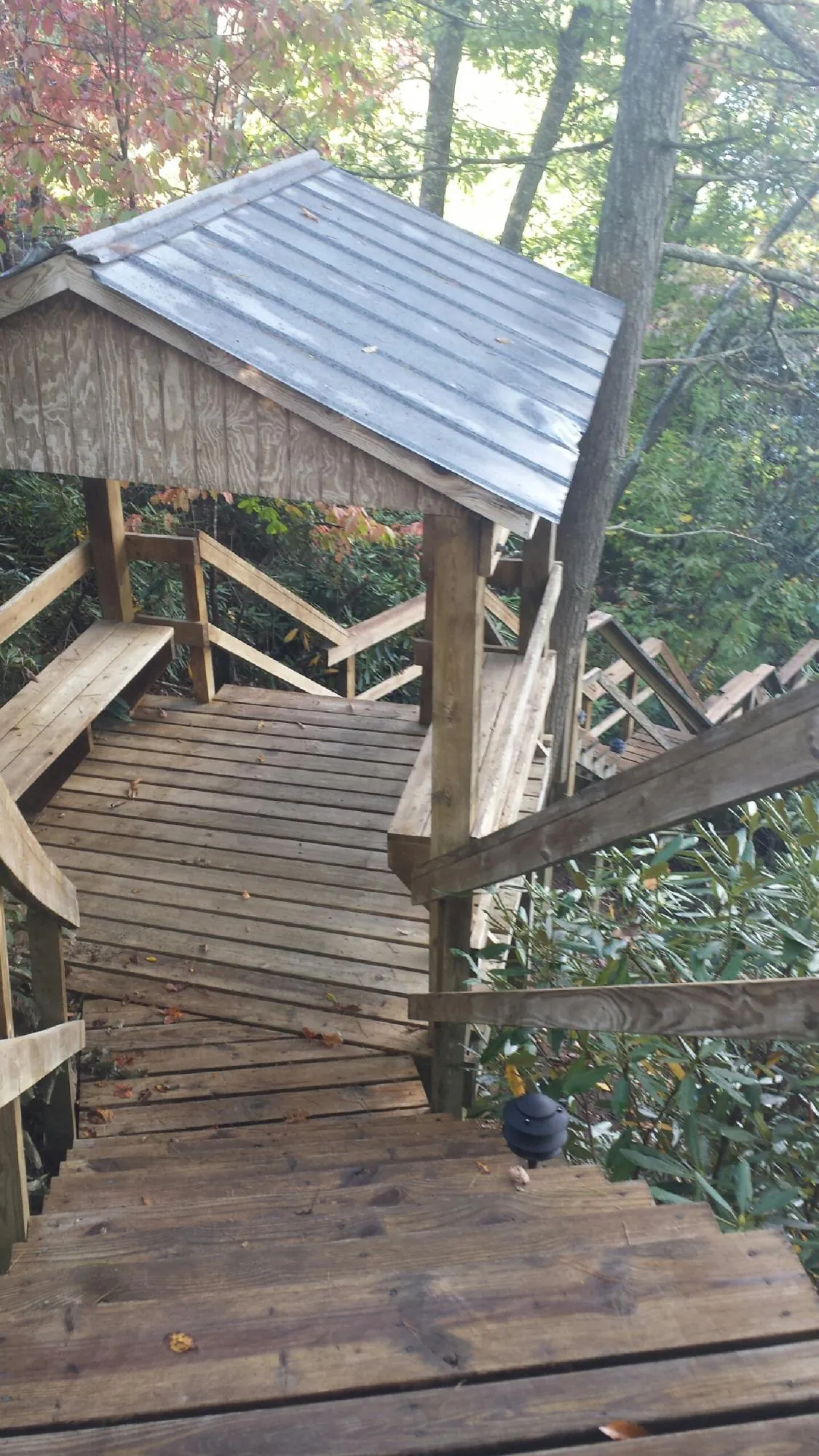 Metal roofed shelter over wooden steps on a wooded walkway — Skylight Repair & Installation work by our crew in Bellmore