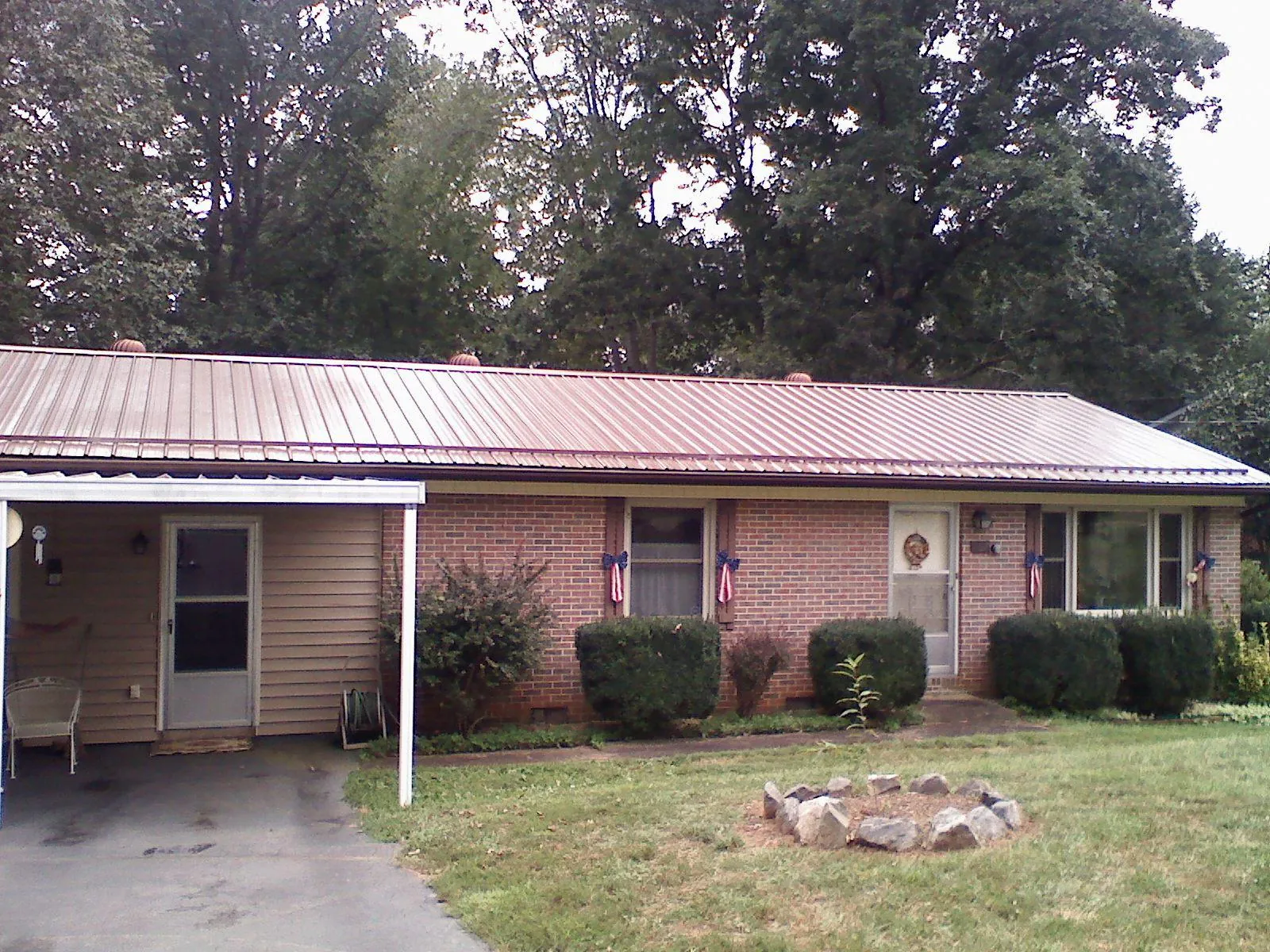 Bronze metal roof and carport on a brick ranch home — Roof Repair work by our crew in Bellmore